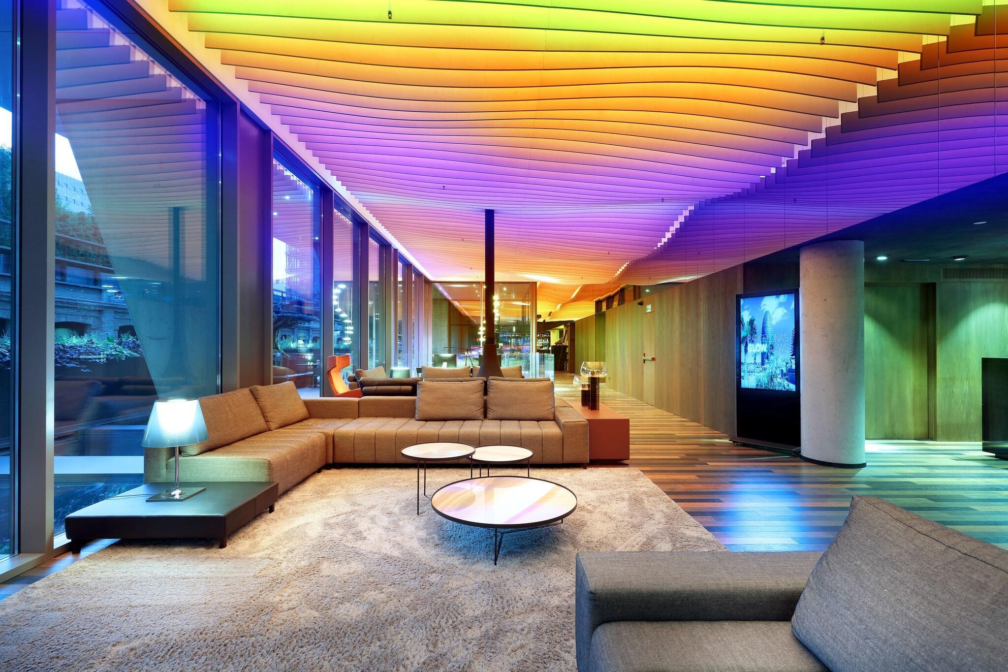 RGB cove lighting creating dynamic color-changing indirect illumination in a contemporary hospitality interior.