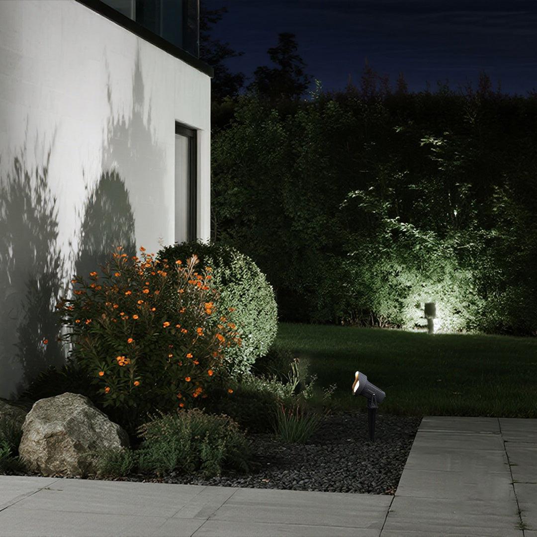 Garden spike lights illuminating trees and landscape elements in a contemporary garden.