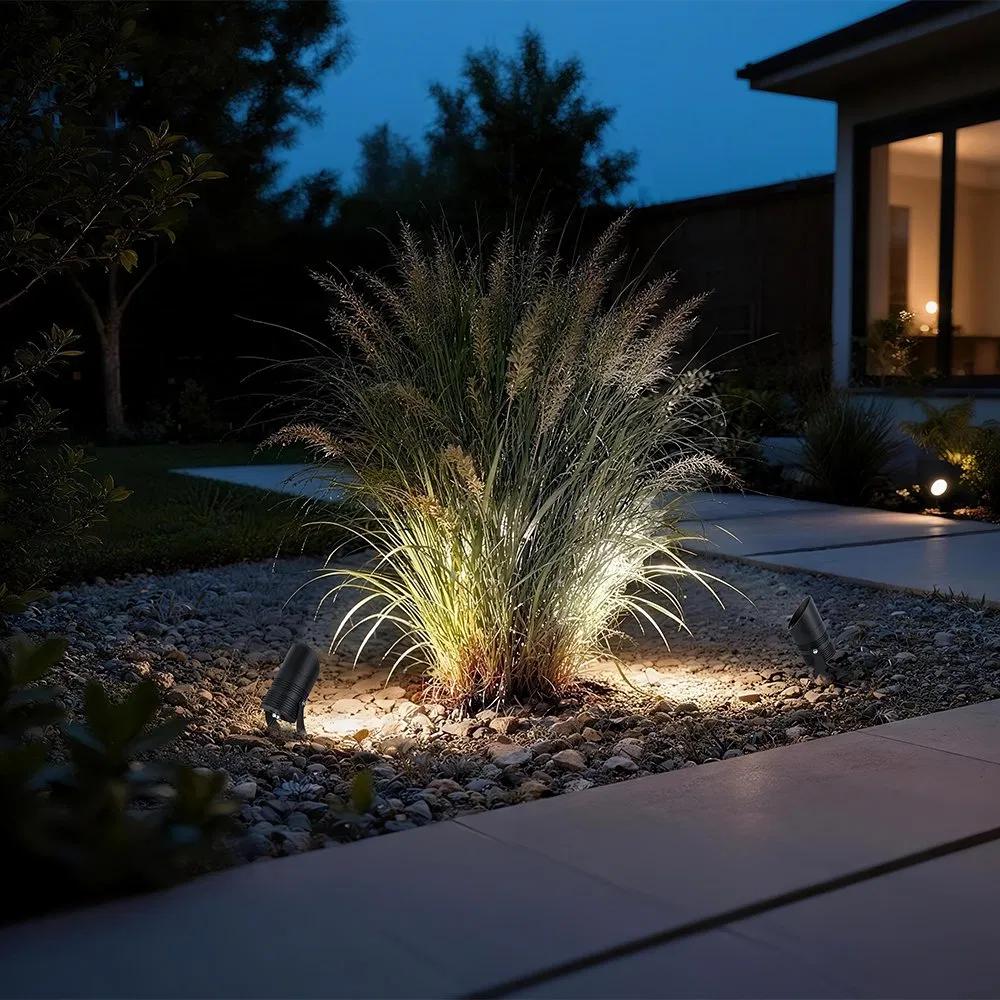 Garden spike lights illuminating trees and landscape elements in a contemporary garden.