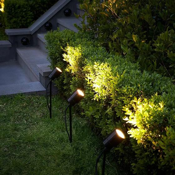 Garden spike lights illuminating trees and landscape elements in a contemporary garden.