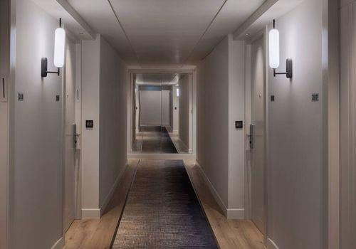 Minimal wall lamp installed in a contemporary hospitality interior.