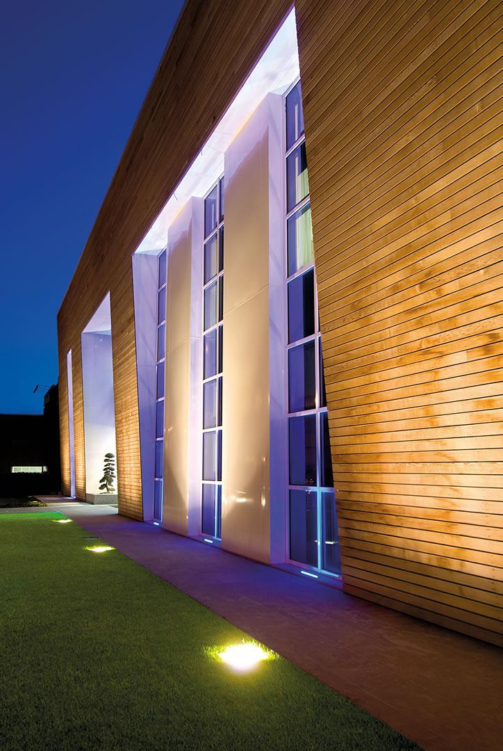 Ground recessed accent spotlights illuminating a building façade and surrounding landscape.