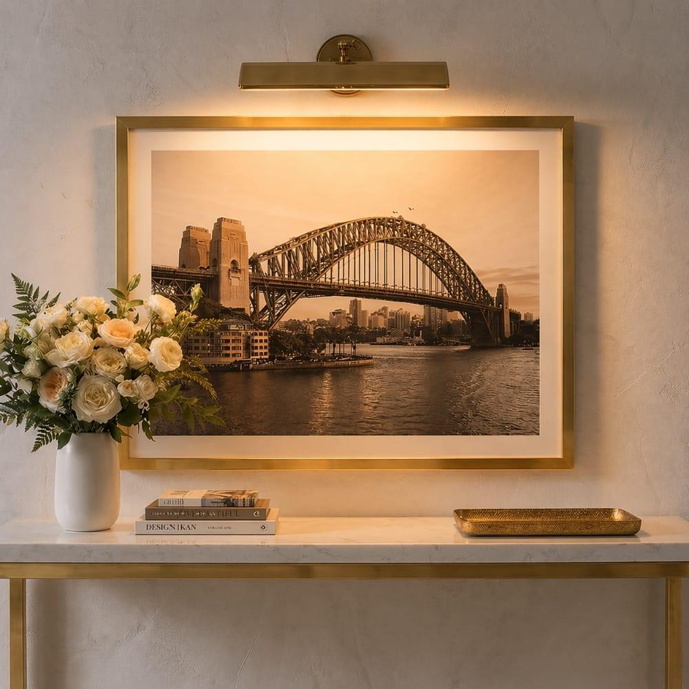 Picture wall lamp illuminating artwork inside a luxury gallery and hospitality interior.