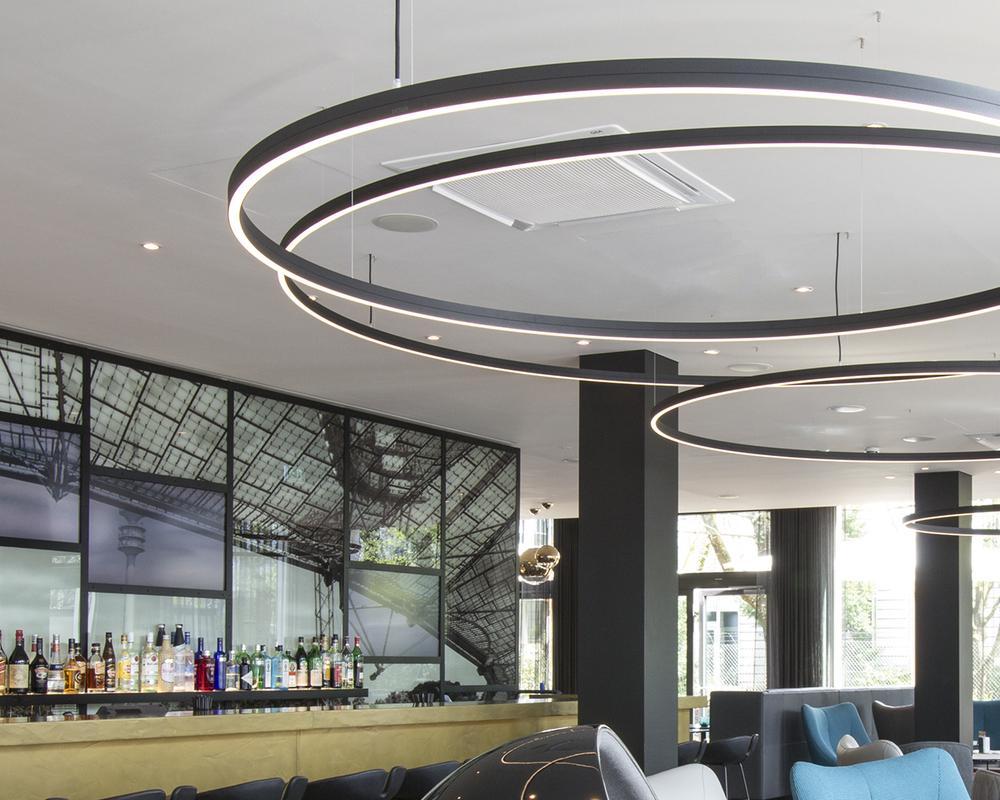 Curved suspended linear lights installed in a contemporary hospitality environment.