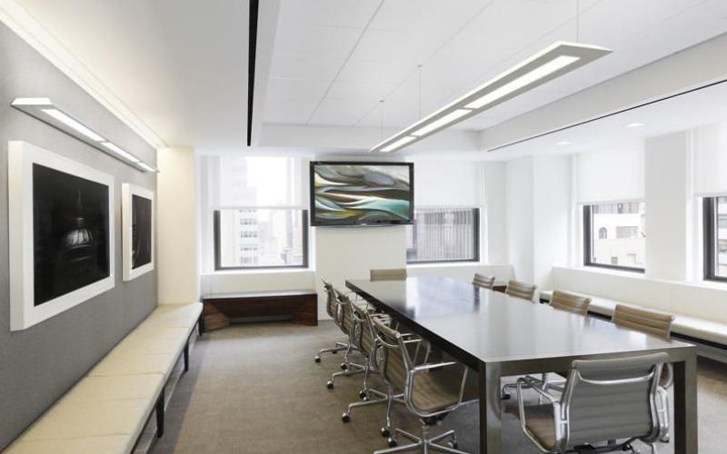 Linear pendant lighting installed in a modern office meeting room.