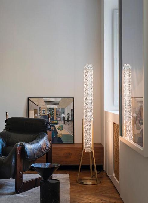 Crystal floor lamp positioned in a luxury hotel lobby creating sparkling reflections and sophisticated ambient lighting.