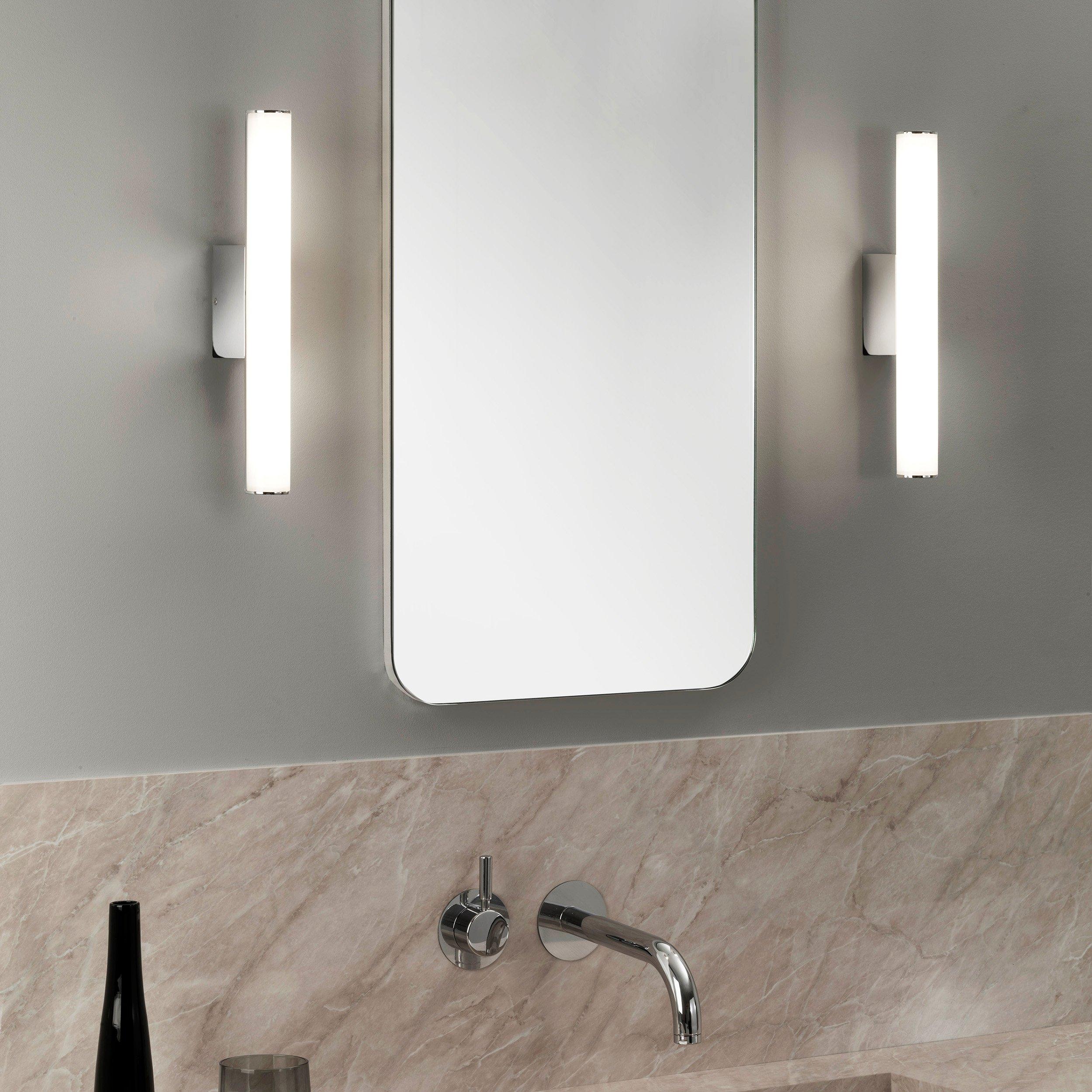 Mirror wall lamp installed beside a luxury hotel bathroom mirror providing balanced illumination.