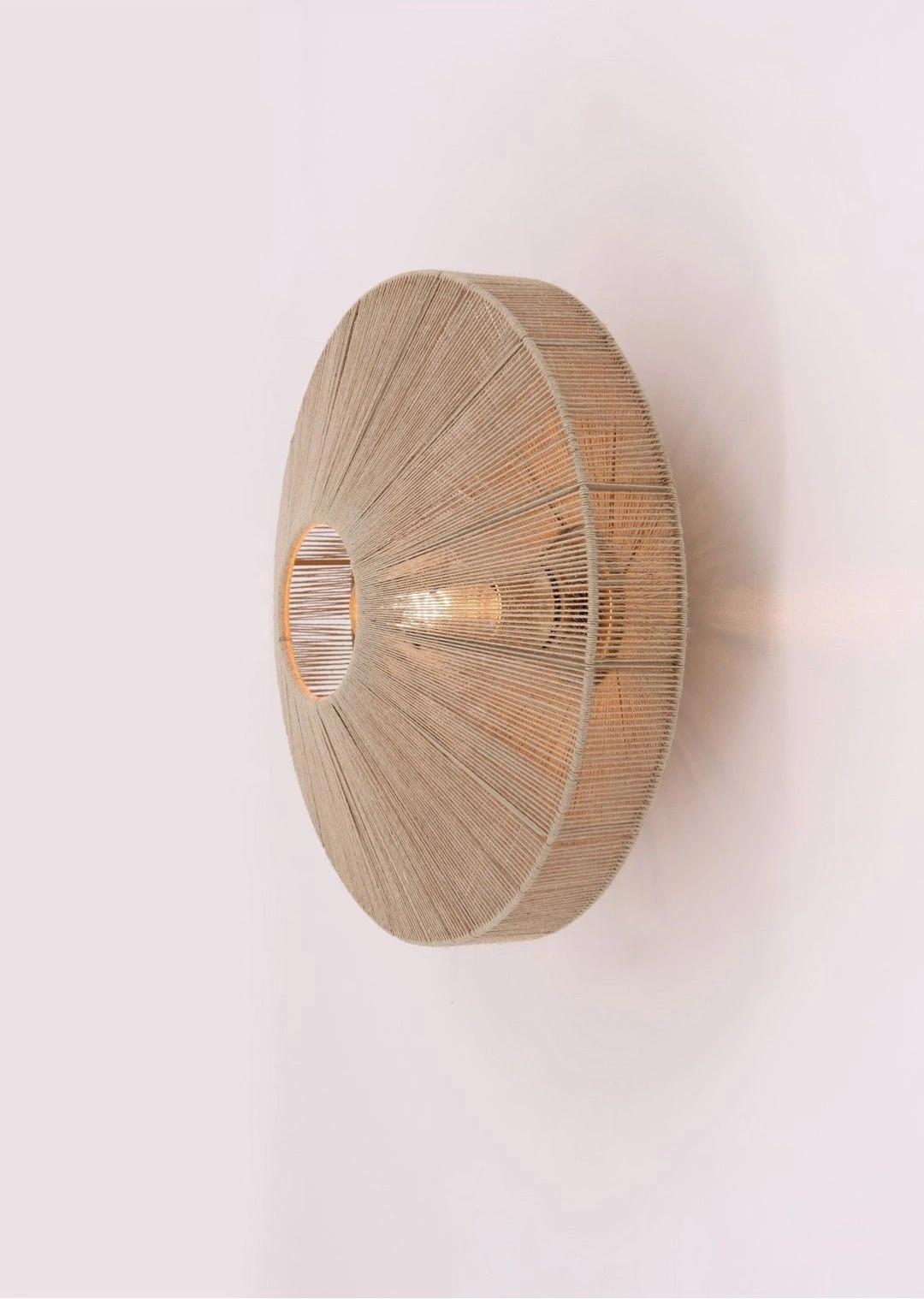 Front view of a woven wall lamp crafted from natural fibers.