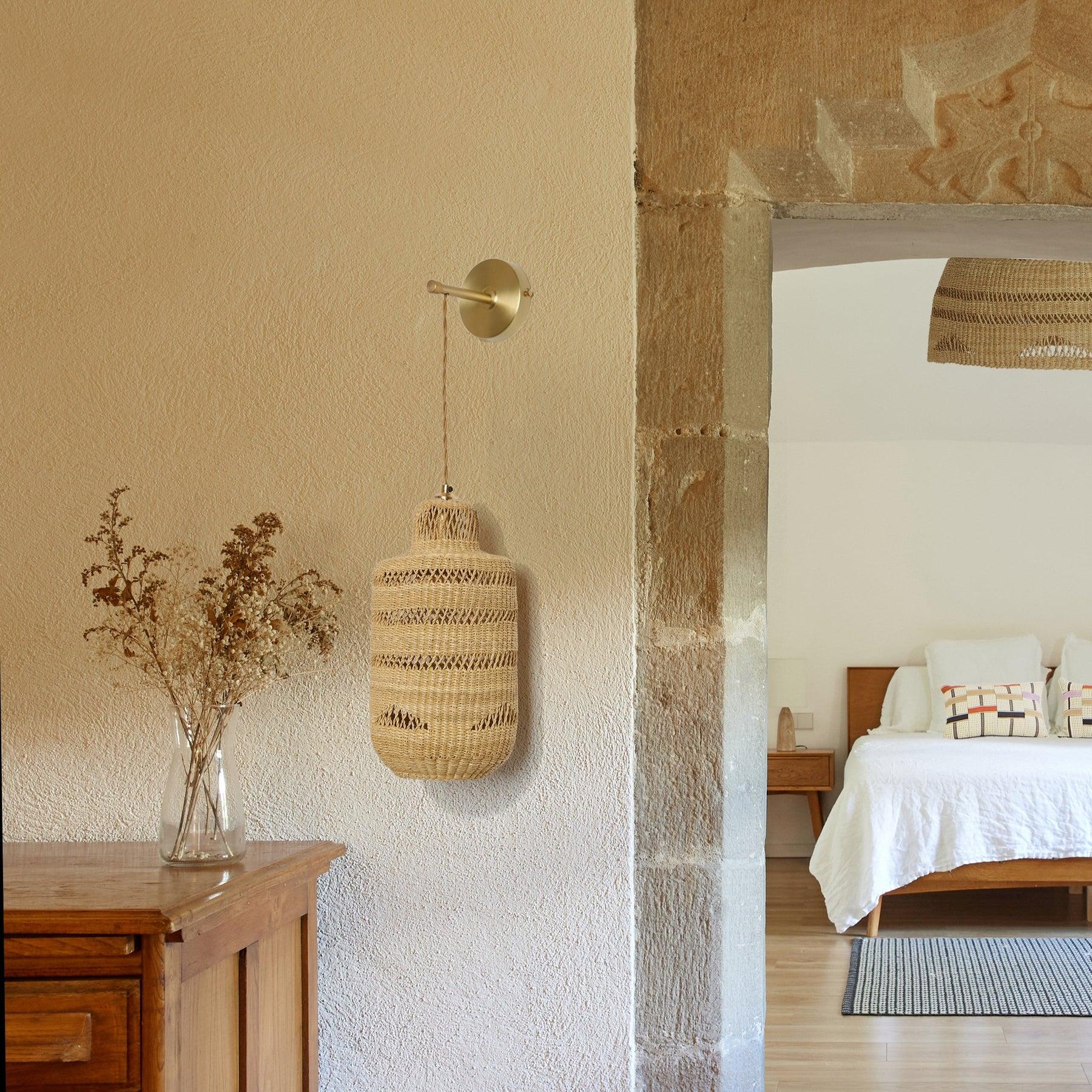 Woven wall lamp installed in a luxury resort interior with contemporary natural architecture.