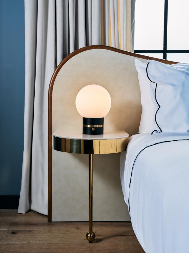 Globe table lamp placed on a luxury hotel bedside table creating soft and balanced ambient illumination.