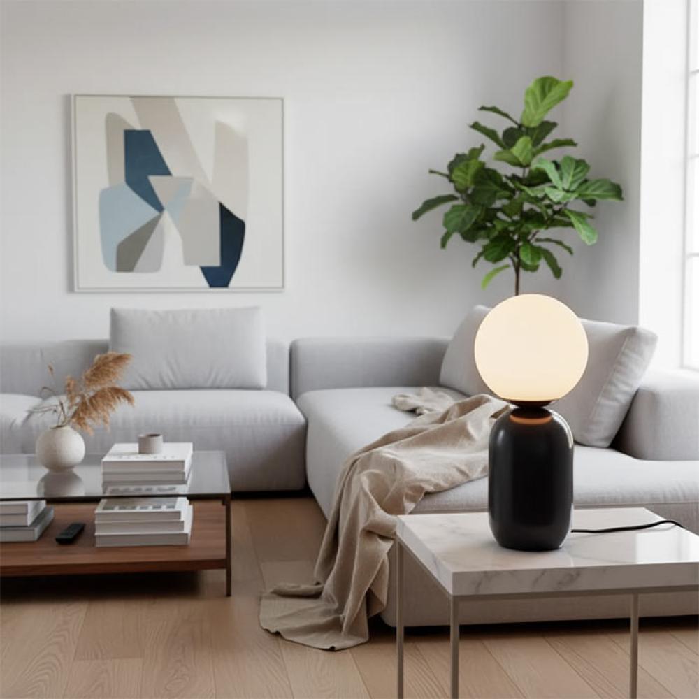Globe table lamp placed on a luxury hotel bedside table creating soft and balanced ambient illumination.