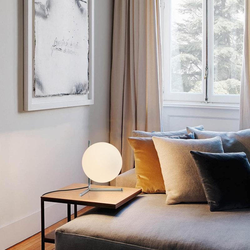 Globe table lamp placed on a luxury hotel bedside table creating soft and balanced ambient illumination.