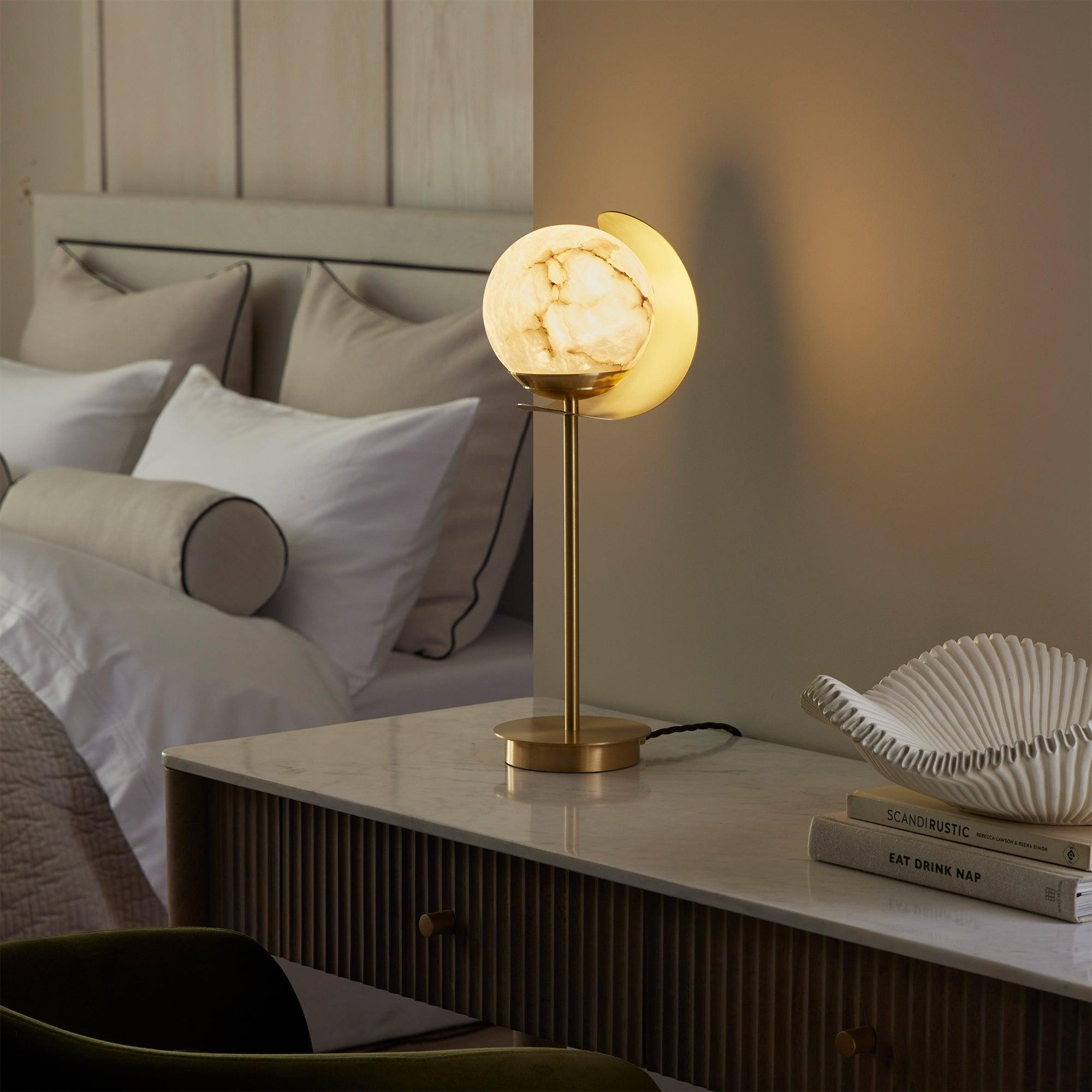 Globe table lamp placed on a luxury hotel bedside table creating soft and balanced ambient illumination.