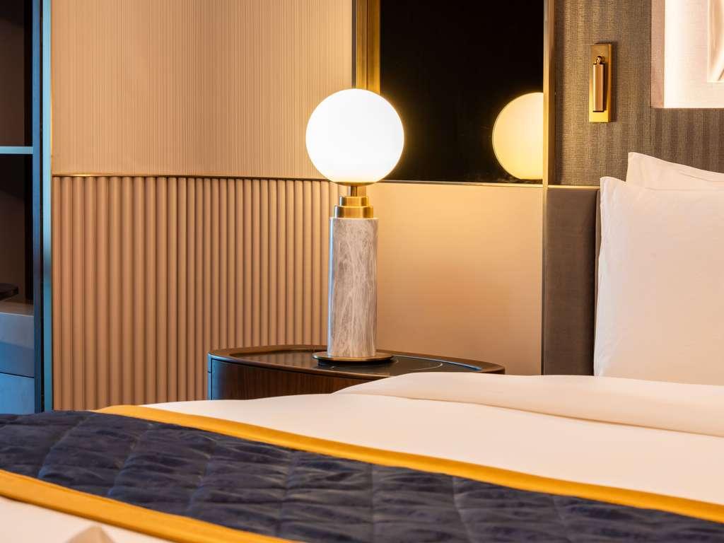 Globe table lamp placed on a luxury hotel bedside table creating soft and balanced ambient illumination.