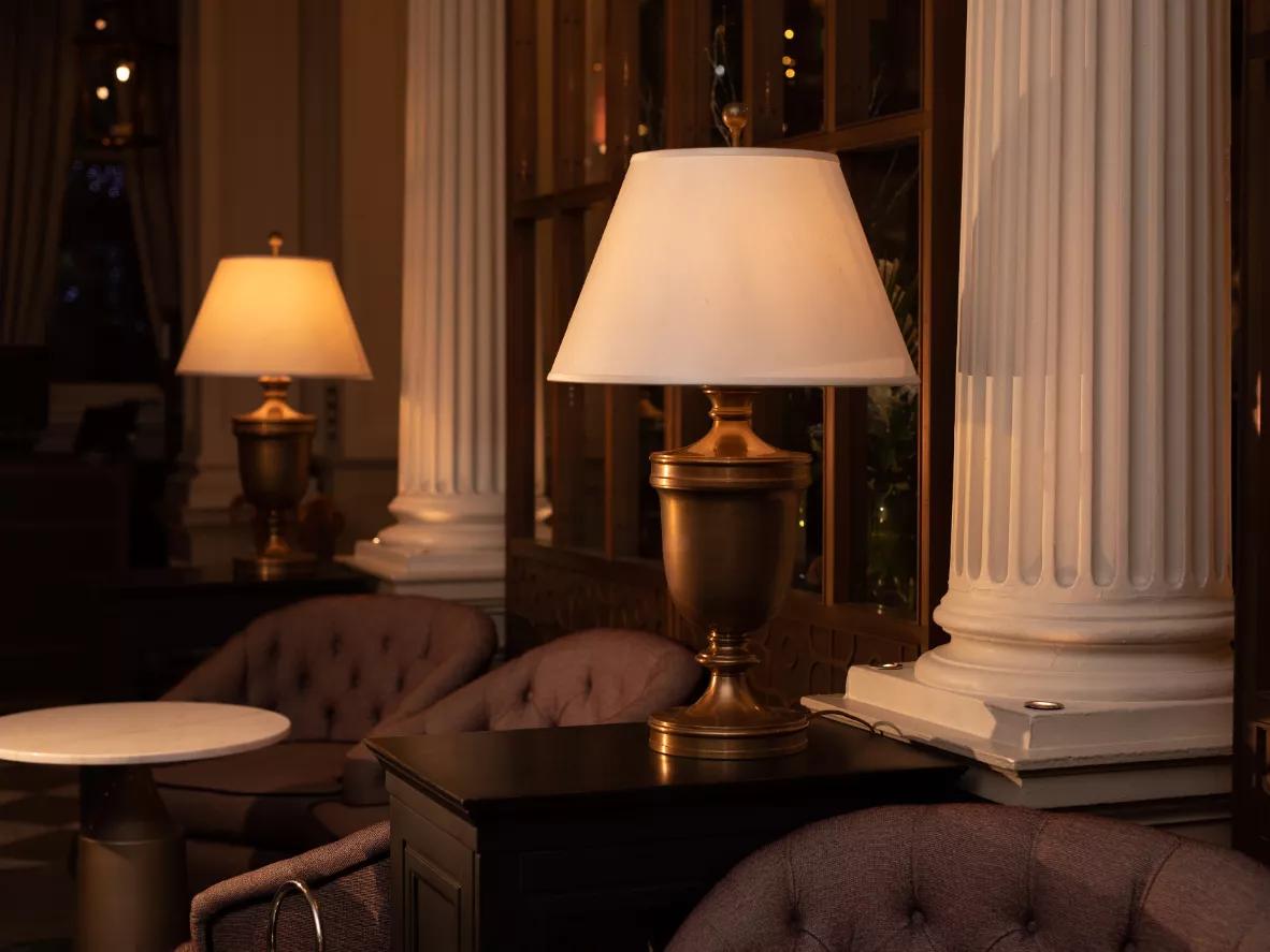 Classic table lamp placed in a luxury hotel lounge creating warm ambient lighting and timeless sophistication.