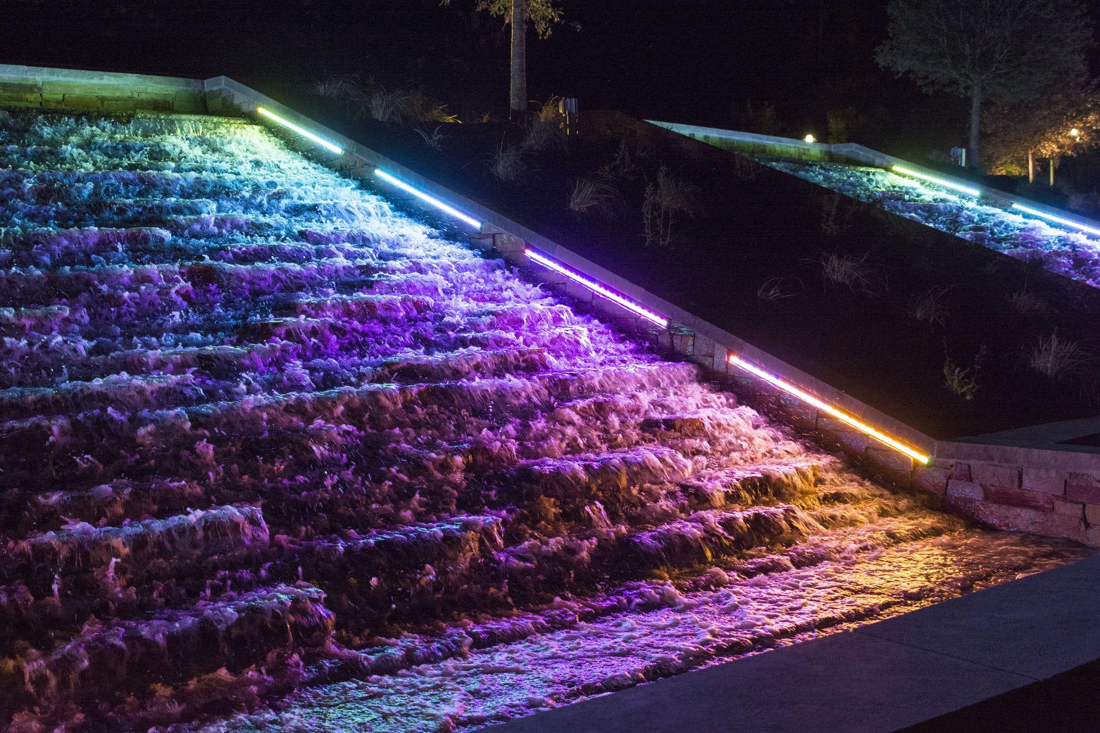 LED underwater linear lights illuminating a fountain and architectural water feature.