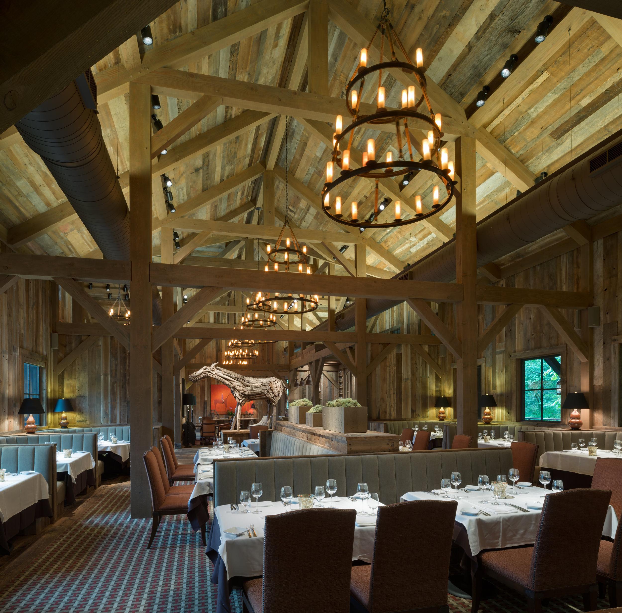 Rustic chandelier installed in a luxury mountain lodge with warm architectural interiors.