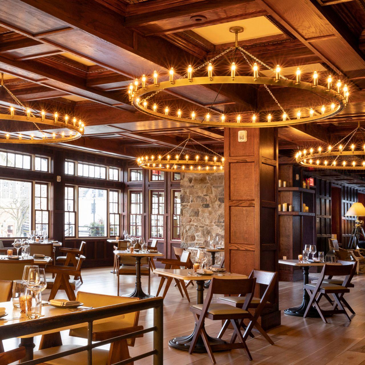 Rustic chandelier installed in a luxury mountain lodge with warm architectural interiors.
