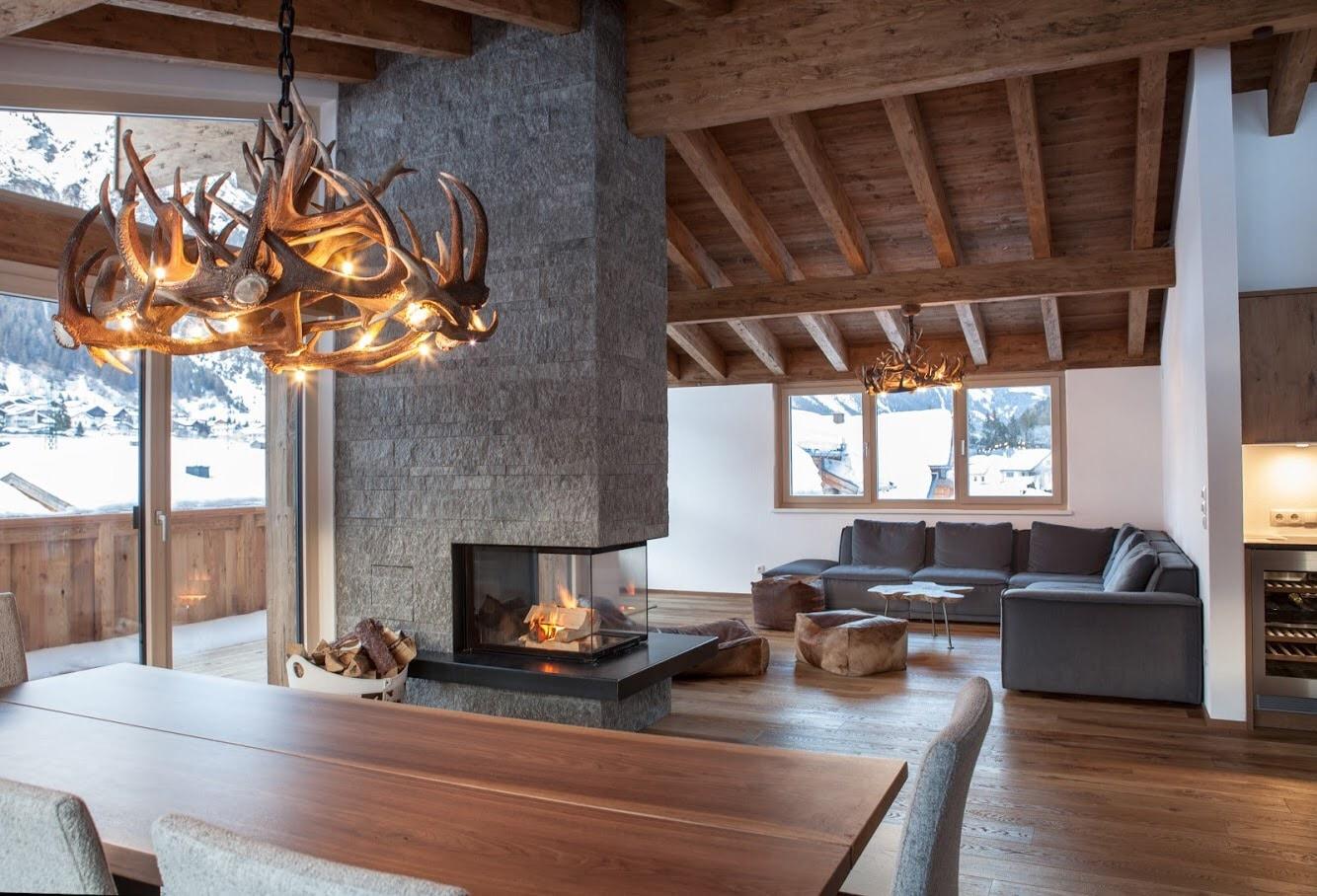 Rustic chandelier installed in a luxury mountain lodge with warm architectural interiors.