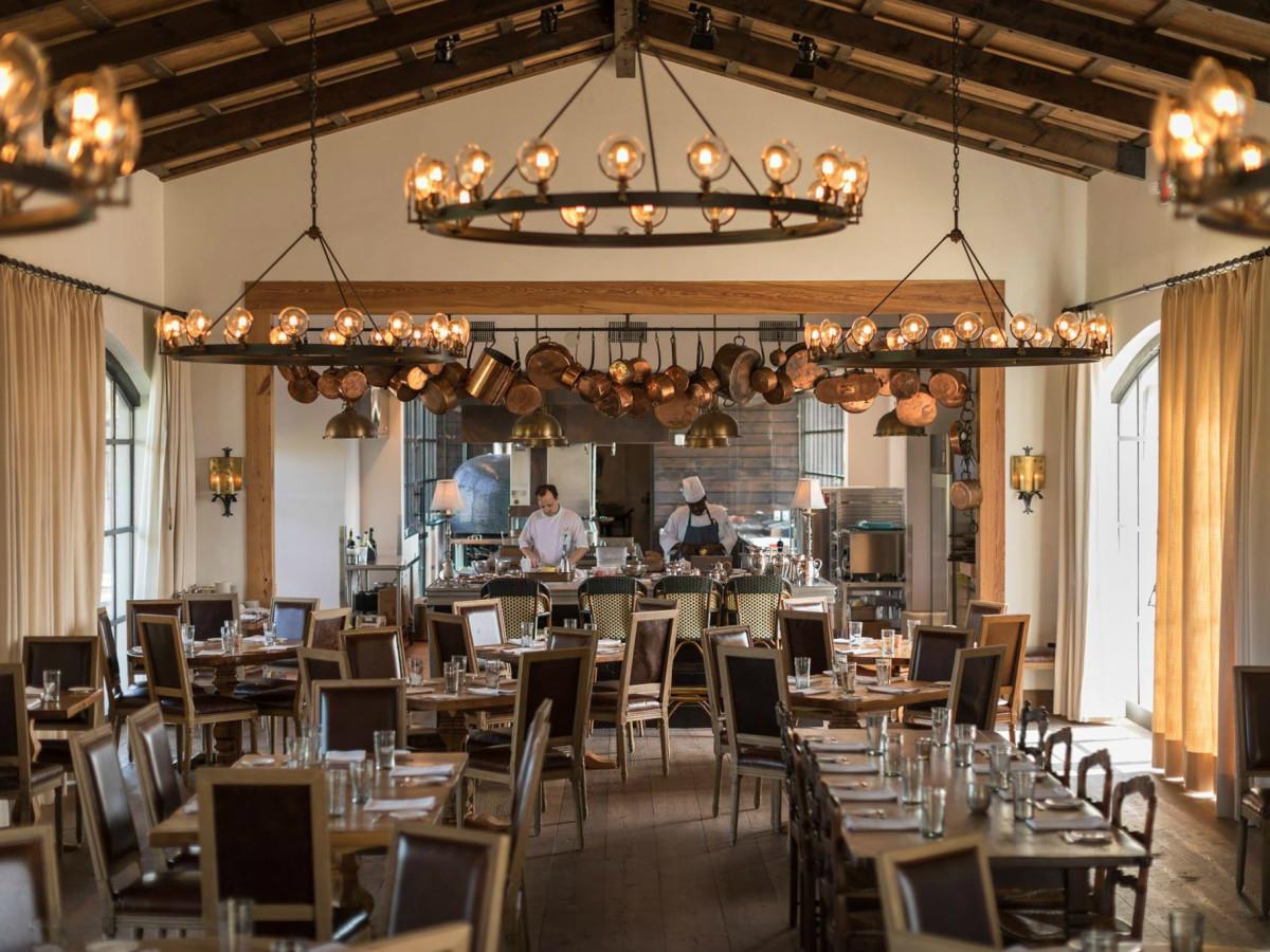 Rustic chandelier installed in a luxury mountain lodge with warm architectural interiors.
