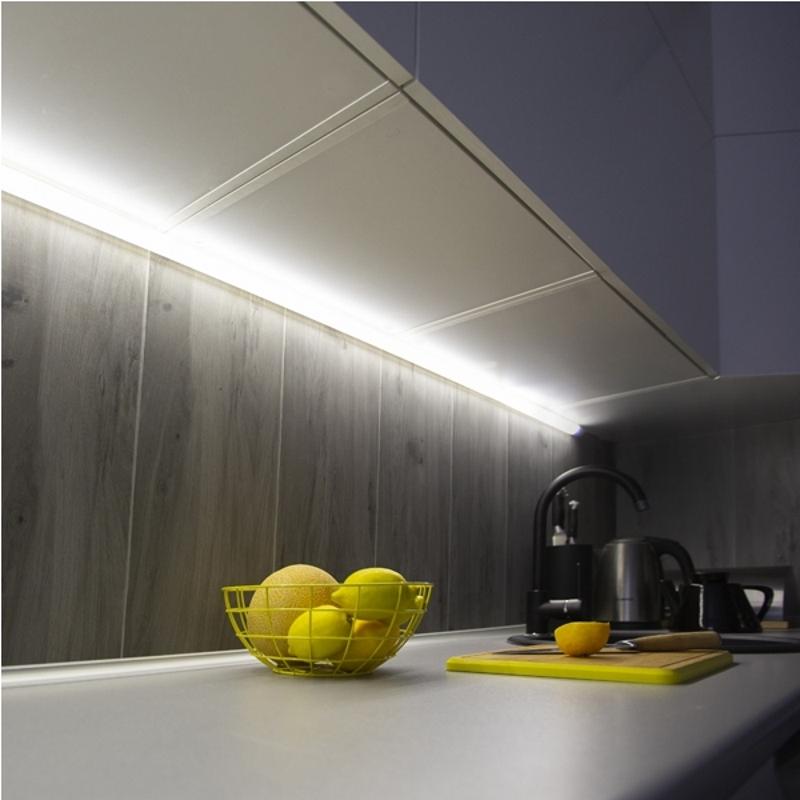 Corner LED profiles installed beneath kitchen cabinets in a contemporary residential interior.