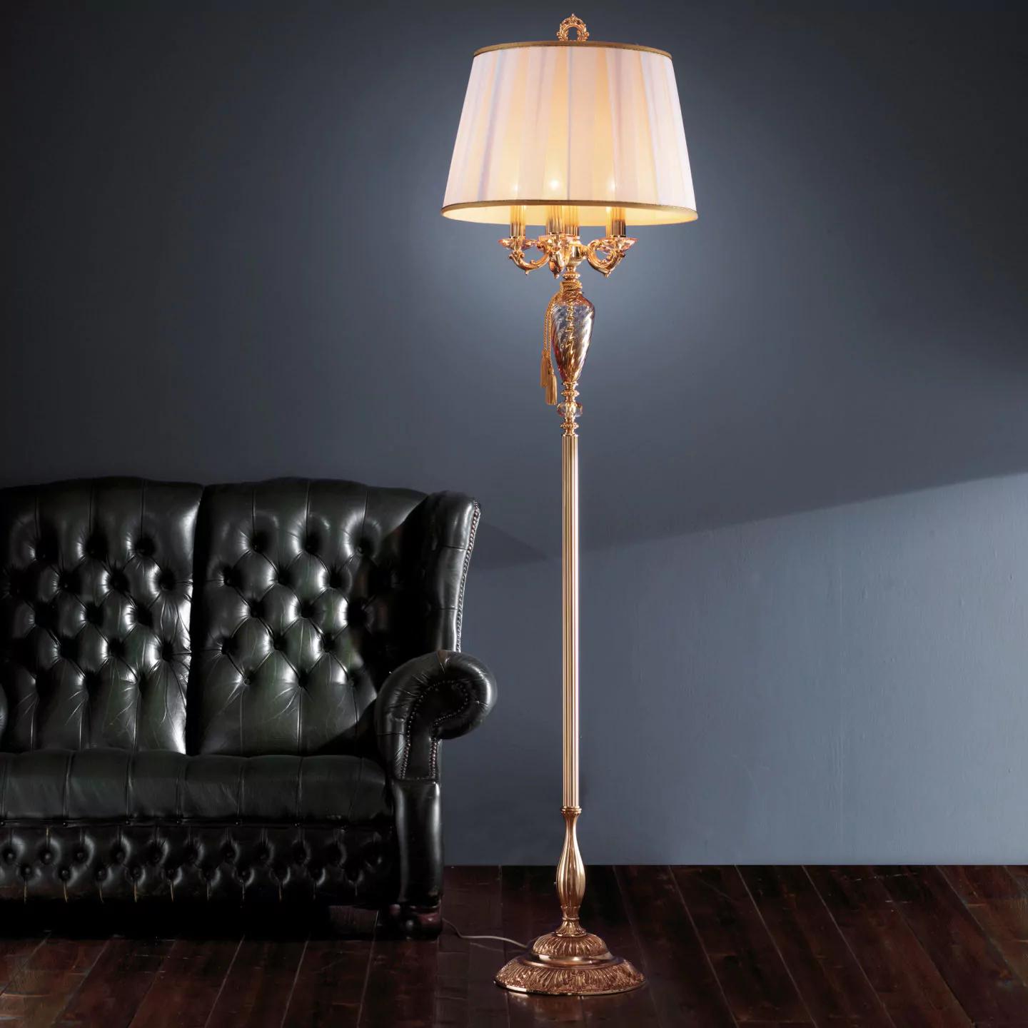 Classic floor lamp positioned beside a seating area in a luxury hotel lounge, creating warm ambient lighting and timeless sophistication.