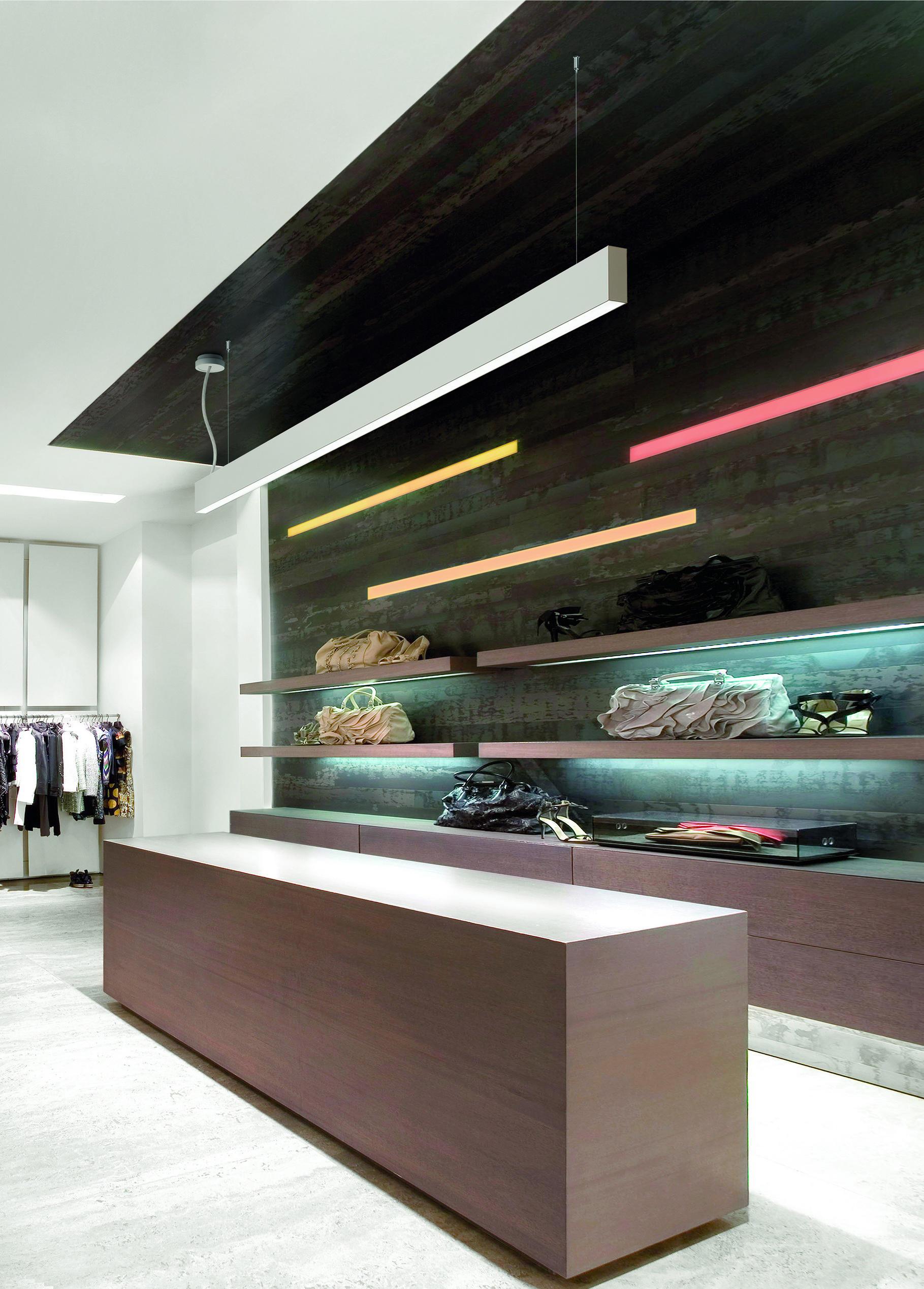 Suspended linear lighting systems installed in a contemporary retail environment.