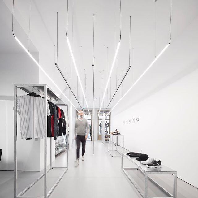 Suspended linear lighting systems installed in a contemporary retail environment.