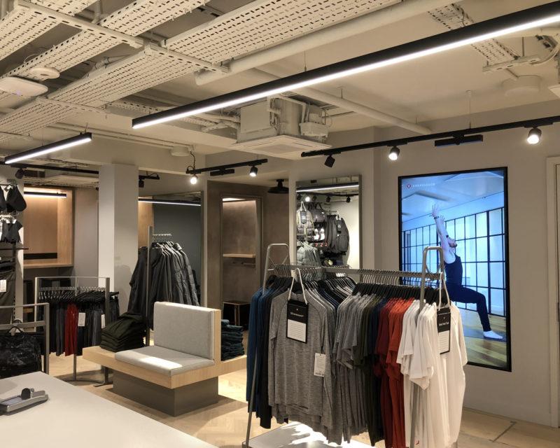 Suspended linear lighting systems installed in a contemporary retail environment.