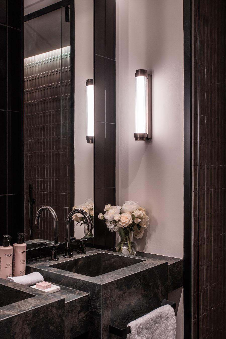 Bathroom wall lamp installed in a luxury hotel bathroom creating soft, balanced architectural lighting.