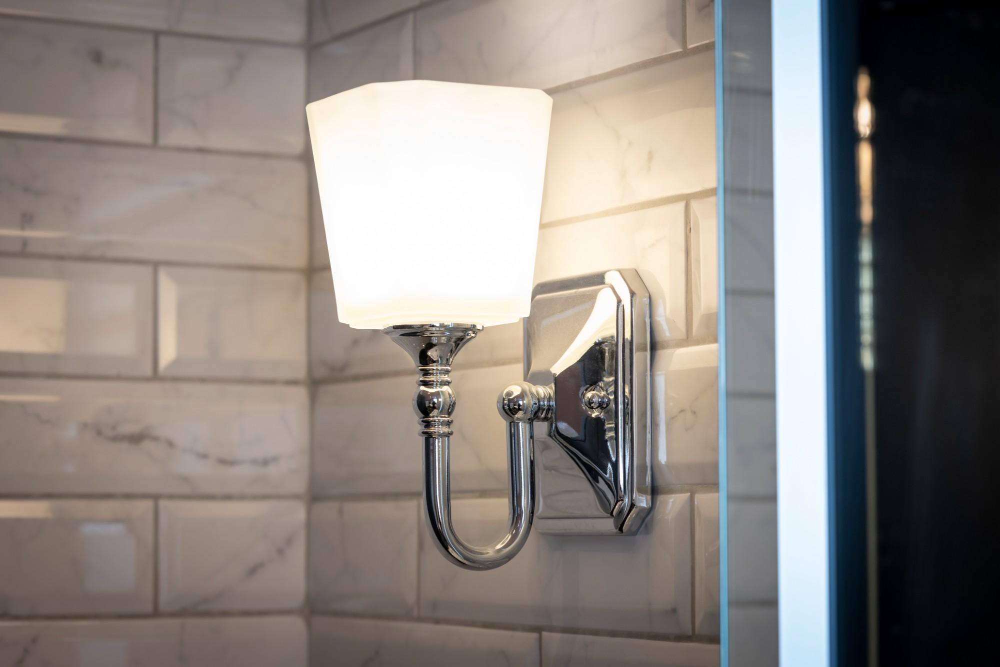 Bathroom wall lamp installed in a luxury hotel bathroom creating soft, balanced architectural lighting.