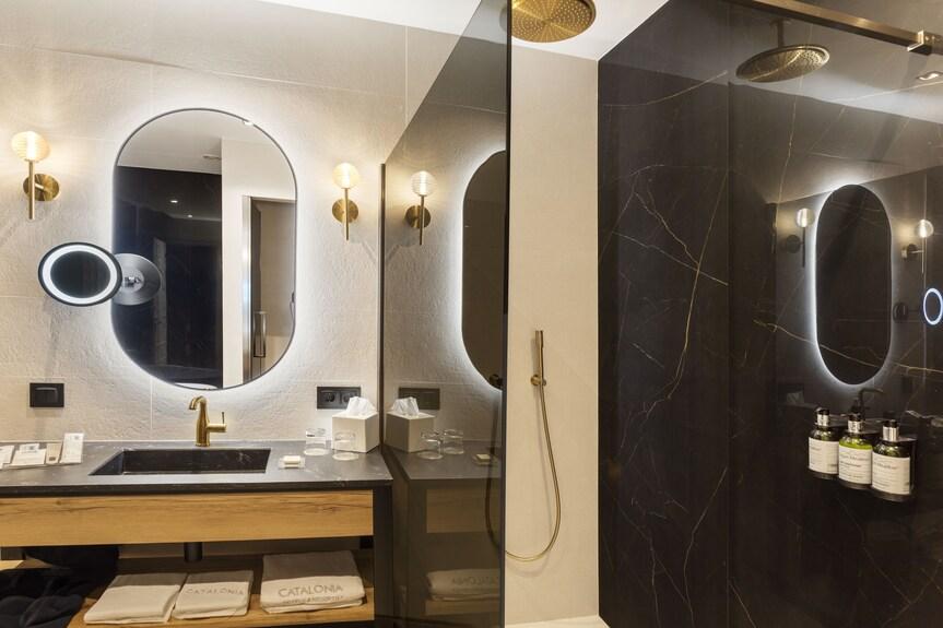 Bathroom wall lamp installed in a luxury hotel bathroom creating soft, balanced architectural lighting.