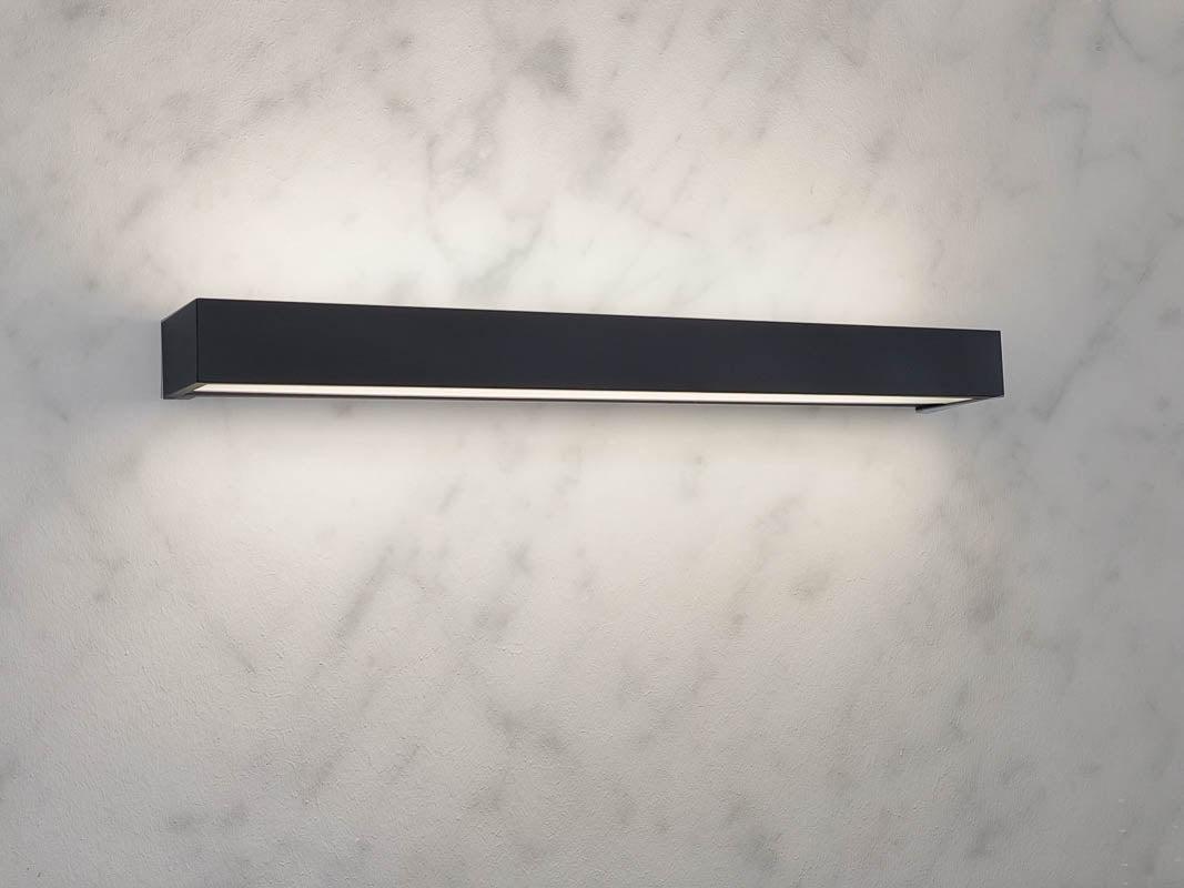 Front view of a decorative bathroom wall lamp with diffused architectural illumination.