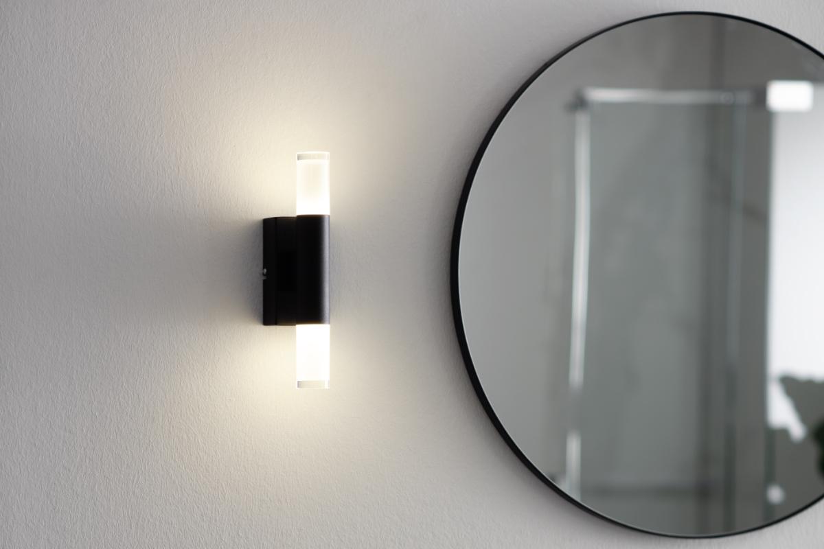Bathroom wall lamp installed in a luxury hotel bathroom creating soft, balanced architectural lighting.