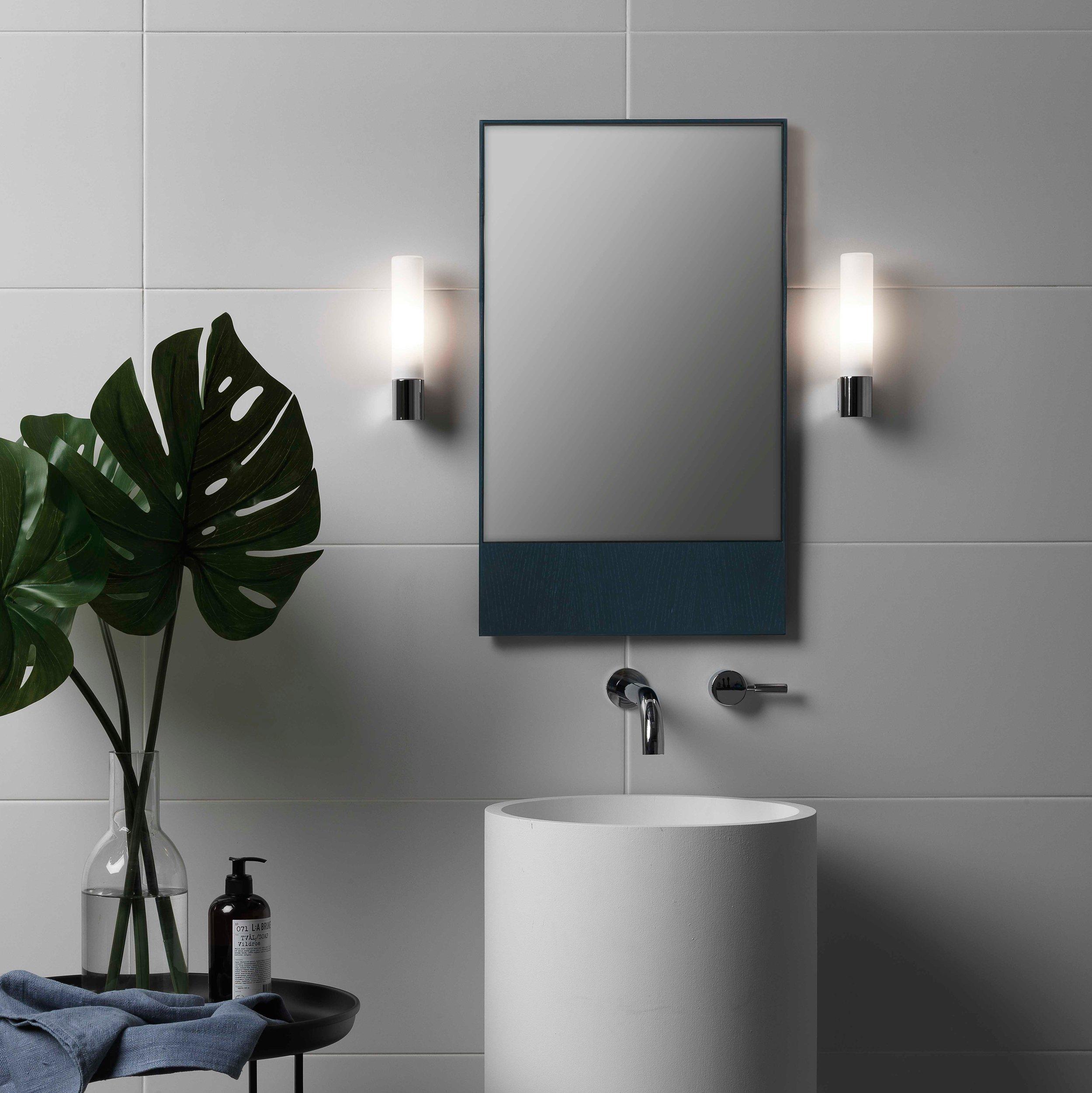 Bathroom wall lamp installed in a luxury hotel bathroom creating soft, balanced architectural lighting.