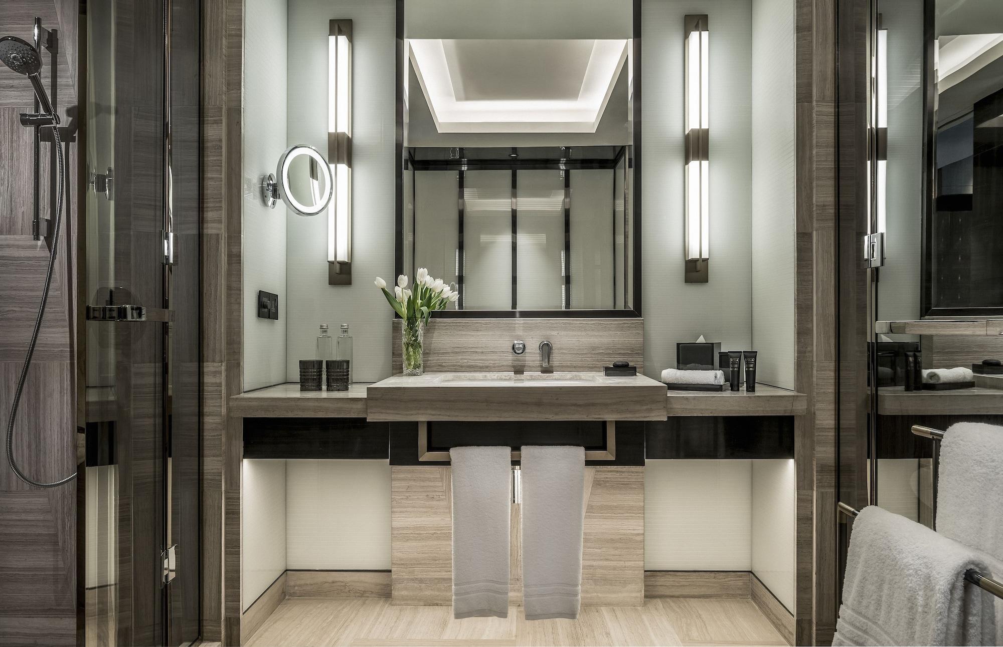 Bathroom wall lamp installed in a luxury hotel bathroom creating soft, balanced architectural lighting.
