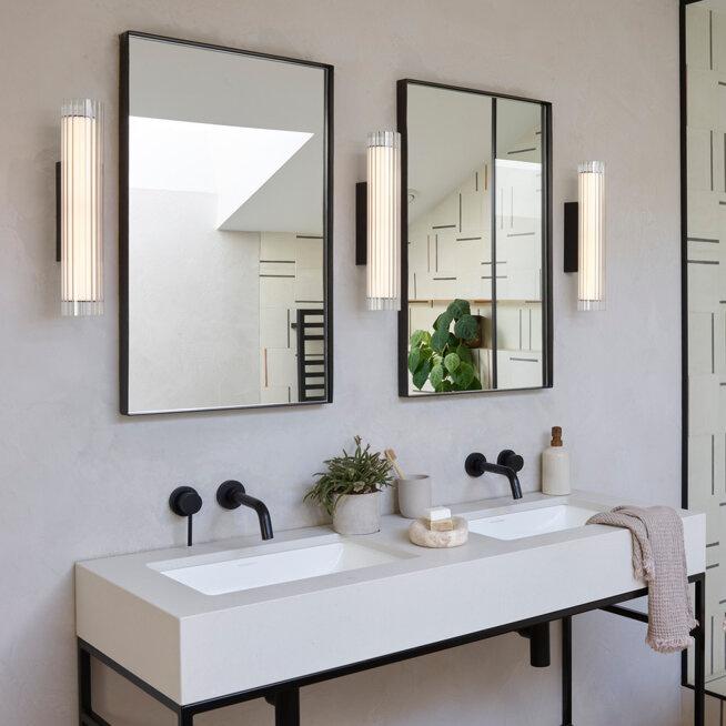 Bathroom wall lamp installed in a luxury hotel bathroom creating soft, balanced architectural lighting.