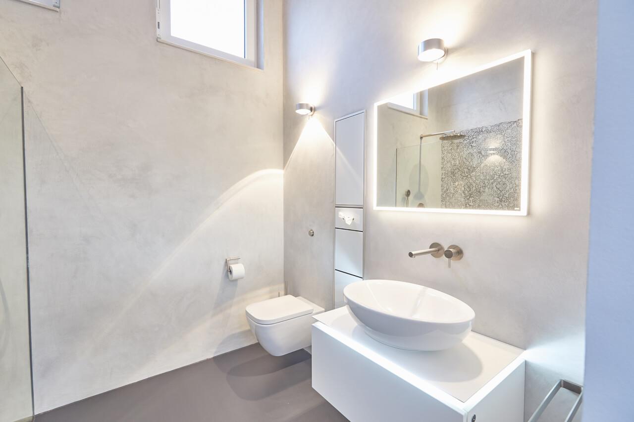 Bathroom wall lamp installed in a luxury hotel bathroom creating soft, balanced architectural lighting.