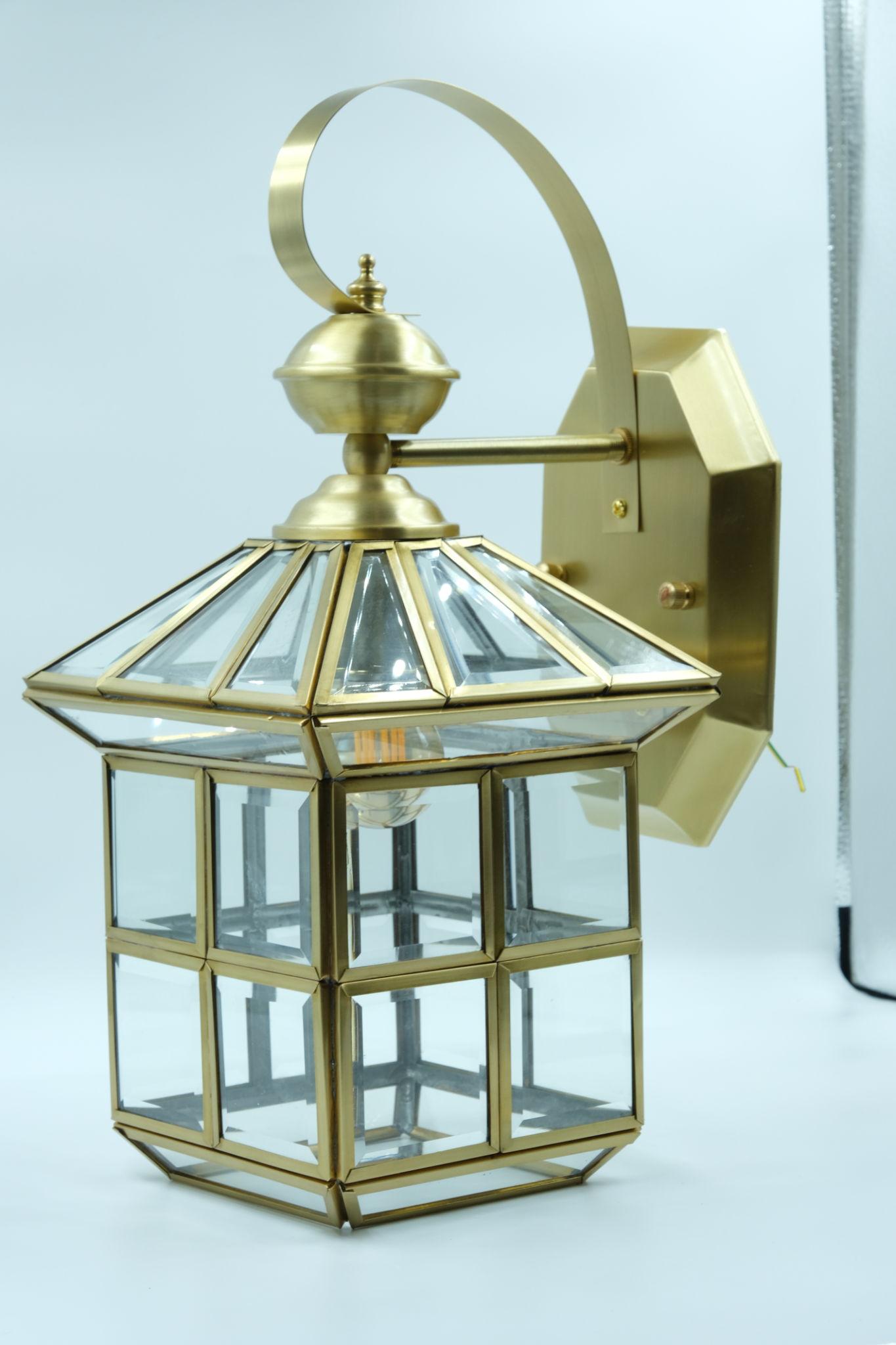 Front view of a lantern-style wall lamp with elegant glass and metal detailing.