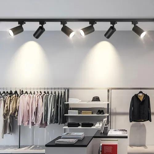 Track-mounted display lighting systems illuminating merchandise in a contemporary retail environment.