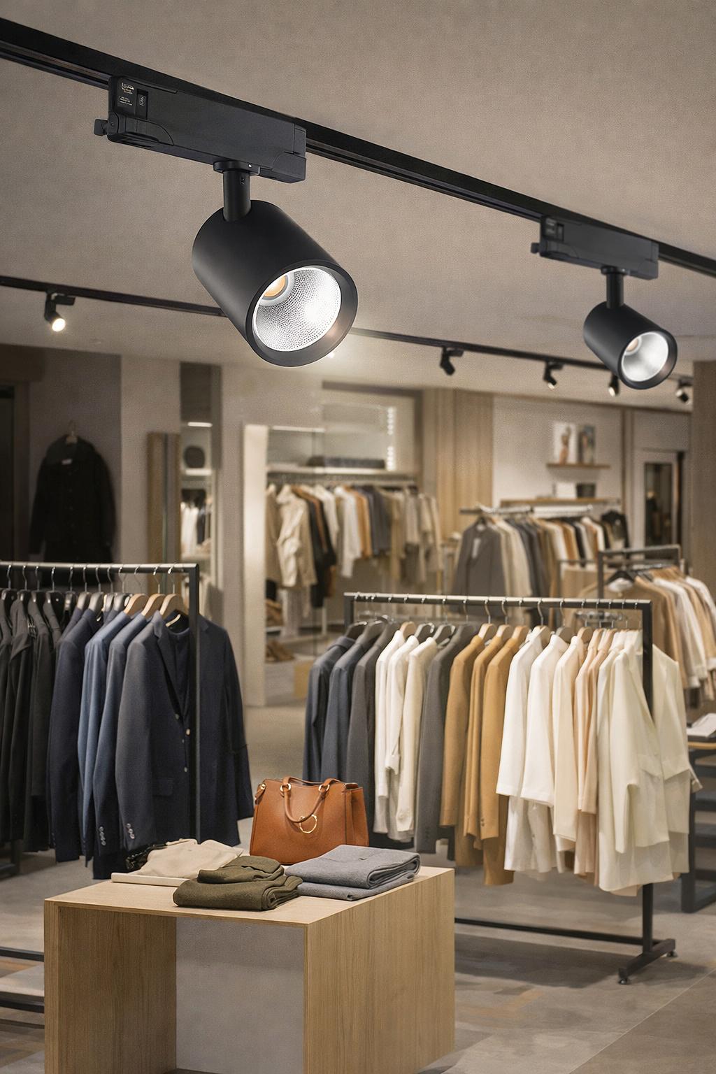 Track-mounted display lighting systems illuminating merchandise in a contemporary retail environment.