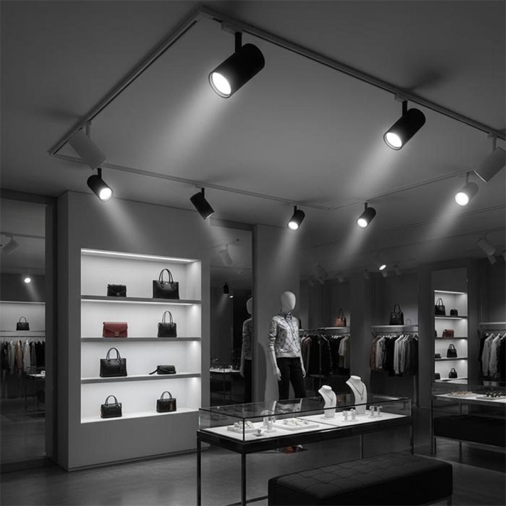Track-mounted display lighting systems illuminating merchandise in a contemporary retail environment.
