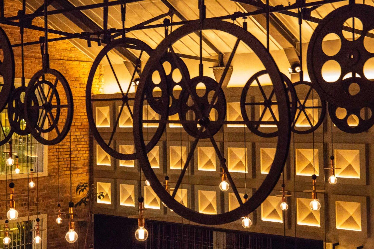 Industrial chandelier installed in a contemporary restaurant with industrial architectural styling.