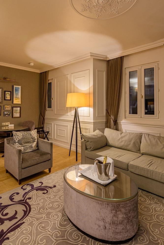 Art Deco floor lamp positioned in a boutique hotel lounge creating a glamorous atmosphere with warm architectural ambient lighting.