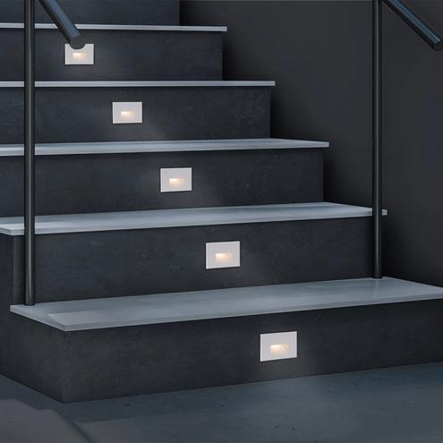 Recessed step lights installed on a contemporary staircase in a hospitality environment.