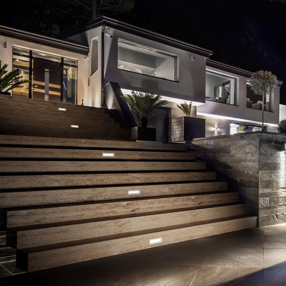 Recessed step lights installed on a contemporary staircase in a hospitality environment.