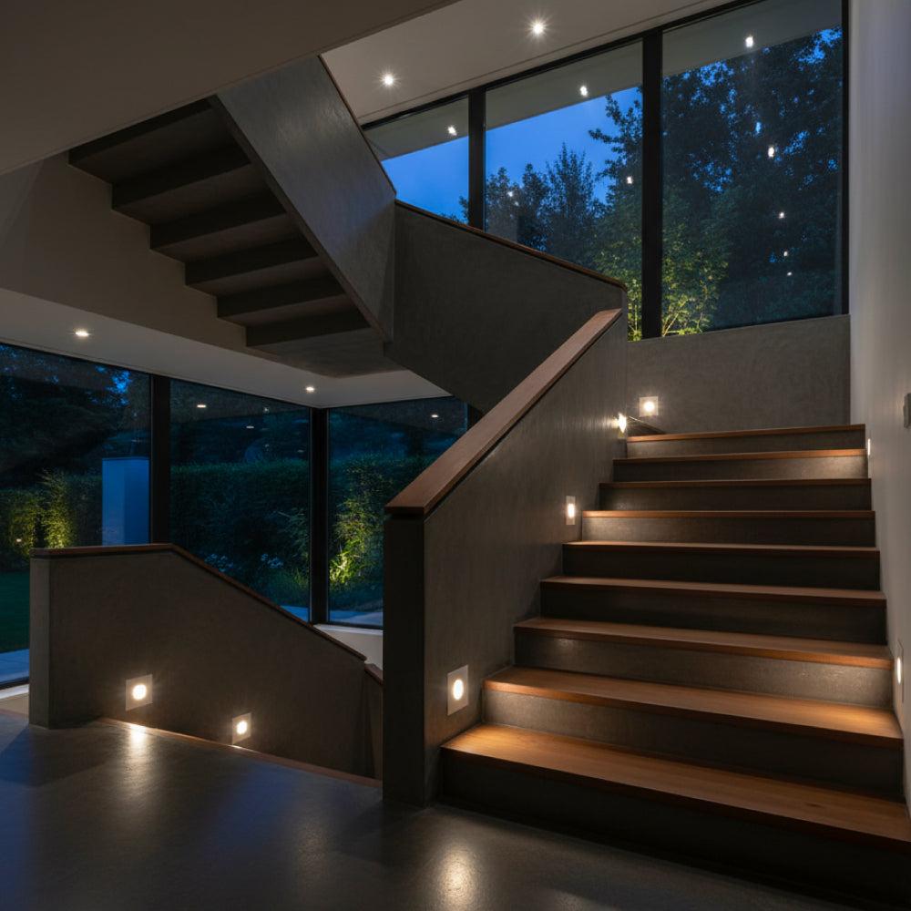 Recessed step lights installed on a contemporary staircase in a hospitality environment.