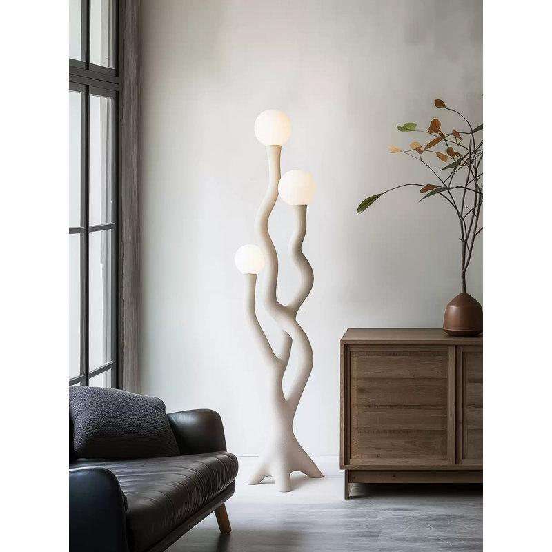 Organic floor lamp positioned beside a lounge chair in a contemporary residential living room creating warm ambient lighting and a calm natural atmosphere.
