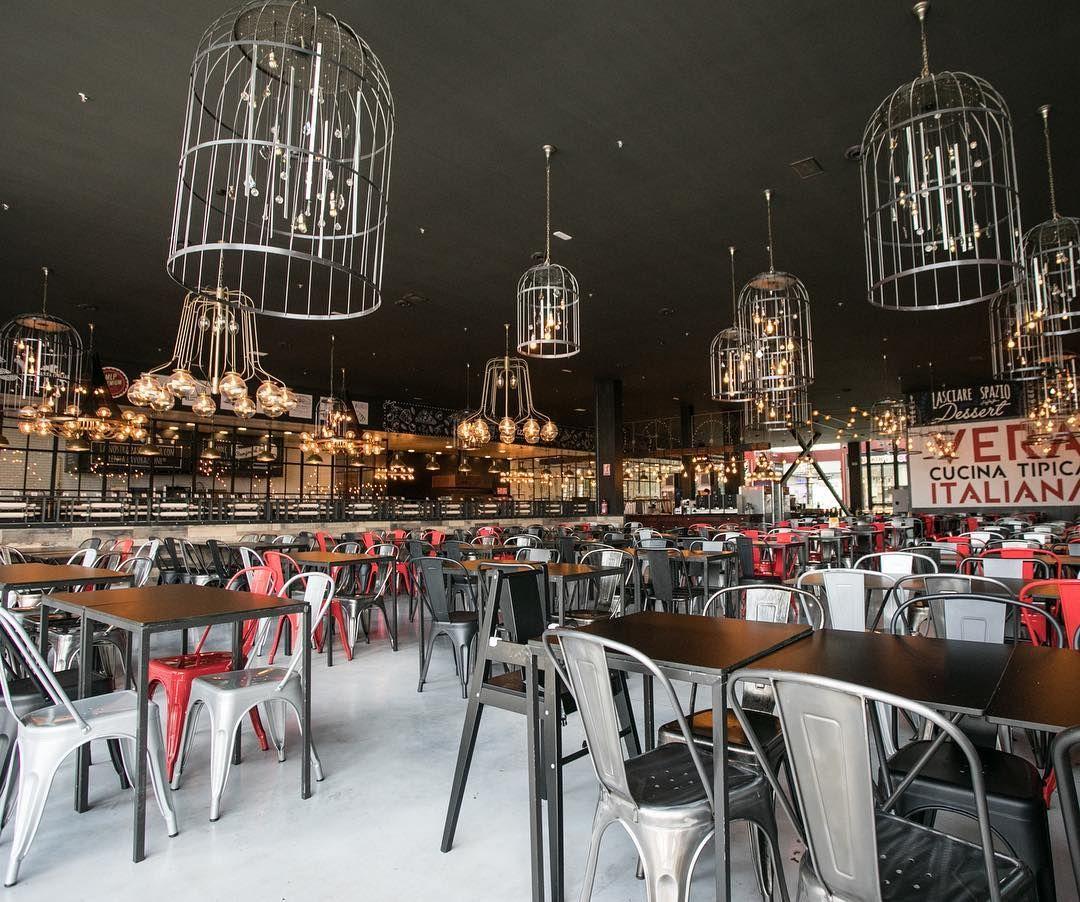 Cage chandelier installed in a contemporary hospitality interior with industrial architectural styling.