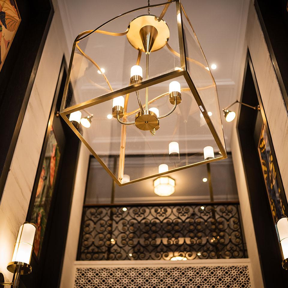 Cage chandelier installed in a contemporary hospitality interior with industrial architectural styling.